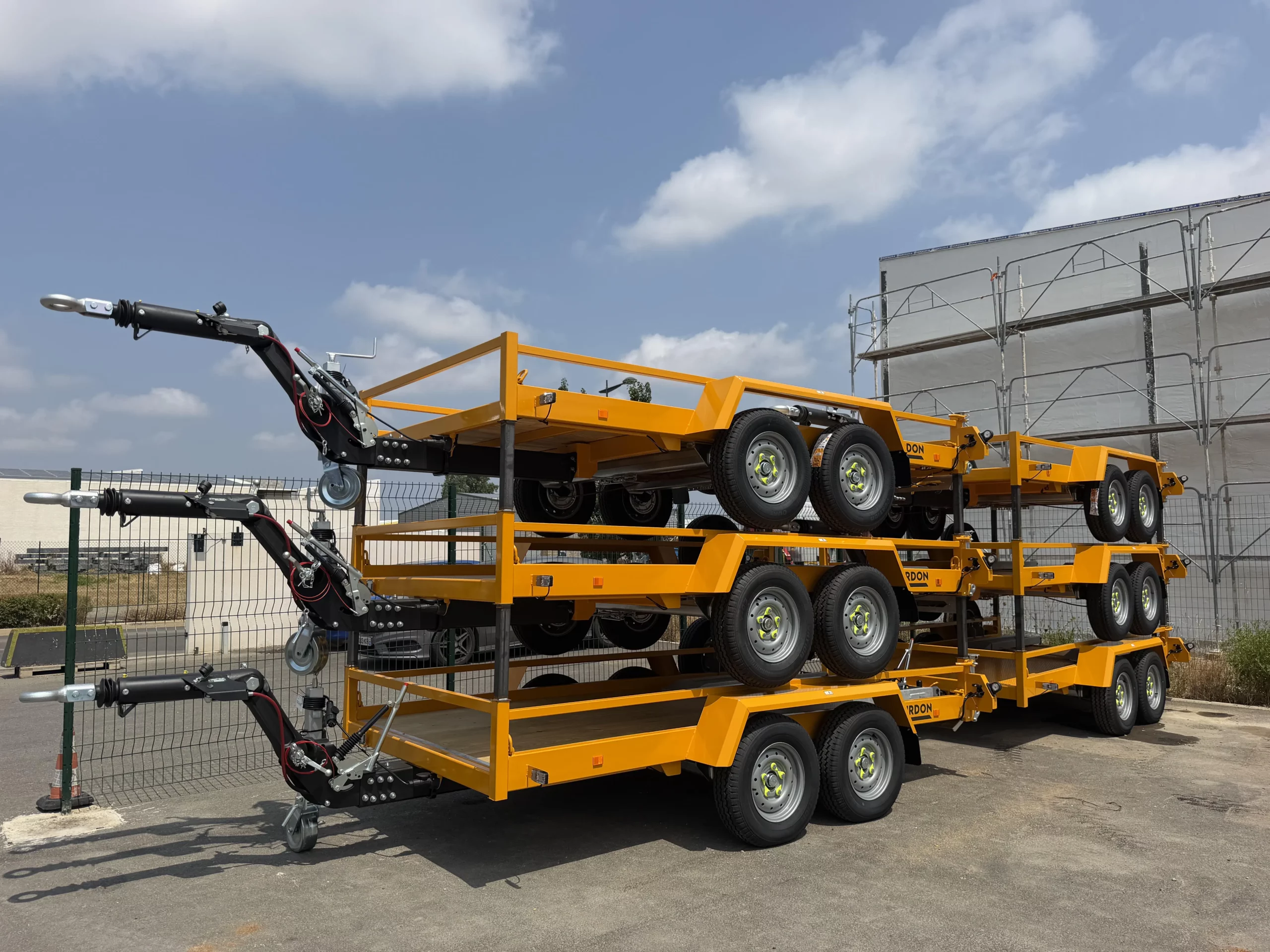 Remorques porte-engins jaunes Gourdon triaxes empilées sur trois niveaux, livraison OCCIMAT distributeur officiel Occitanie